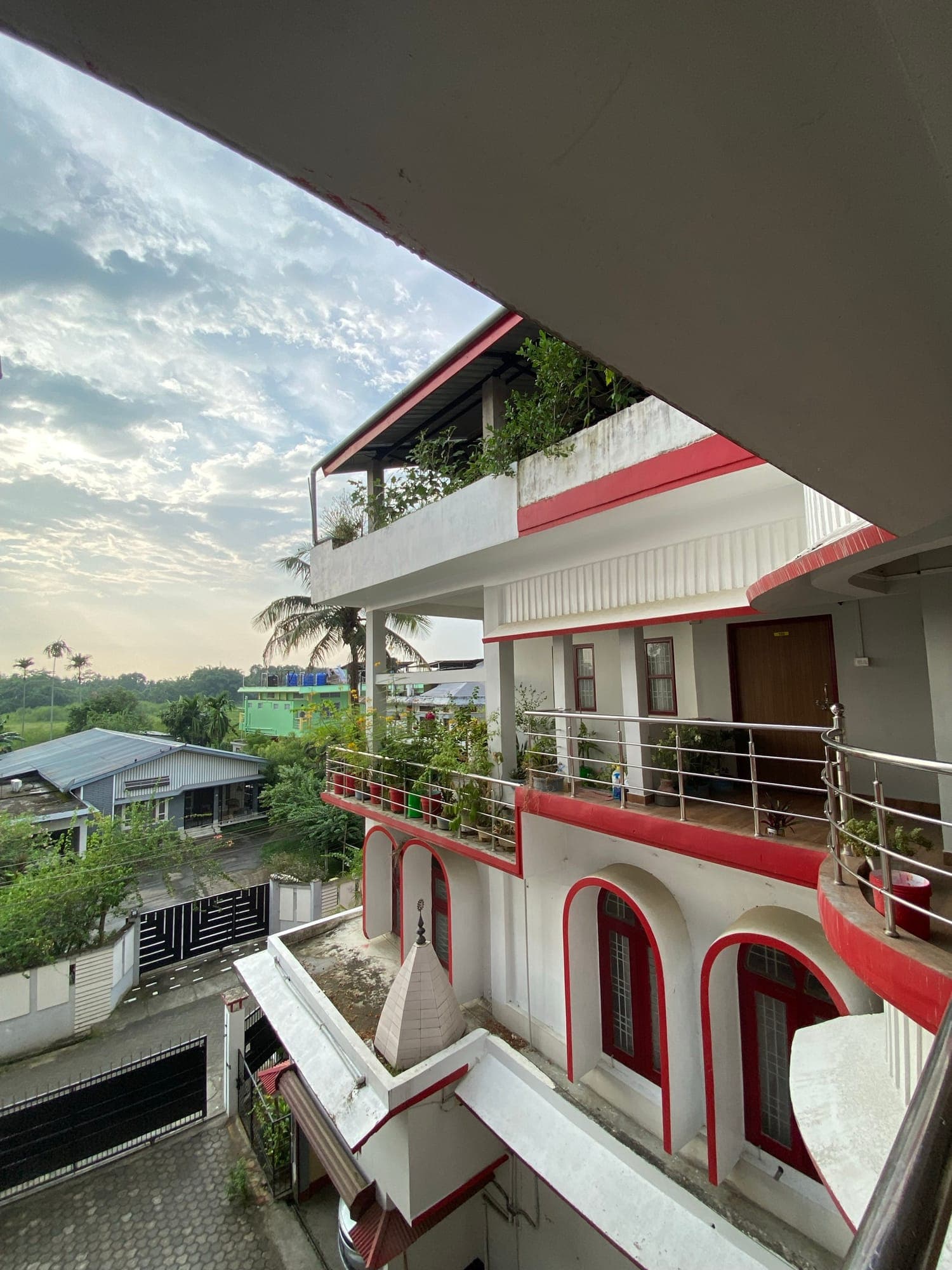 The Birdhouse Homestay's white and red facade at sunset